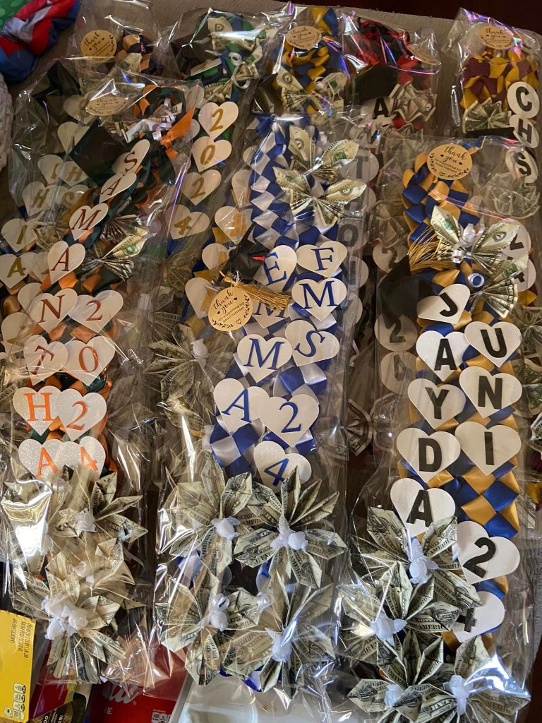 A variety of graduation leis with the grads' names and graduation years